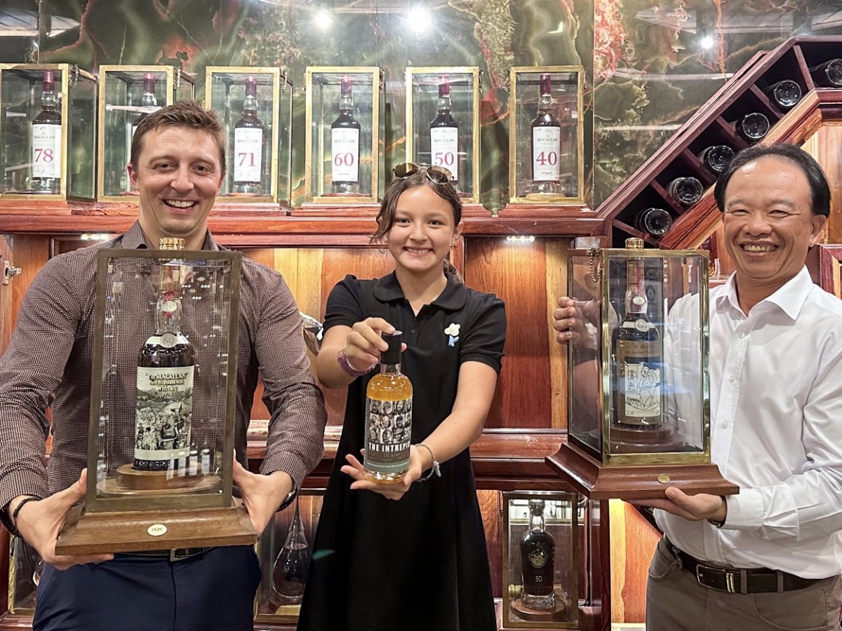 In the middle, there's “The Intrepid” 32-Year-Old Macallan half-litre replica, on the left Mr Monk holds “The Macallan 1926 60-Year-Old Sir Peter Blake”, and on the right Mr Viet holds “The Macallan 1926 60-Year-Old Valerio Adami” 